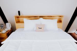 a bedroom with a white bed with a sign on it at Dieng Khatulistiwa By Travelink in Diyeng