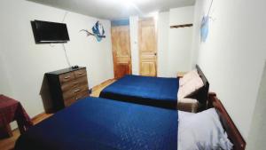 a bedroom with a bed and a dresser and a tv at Huachuma Rooms in Huaraz +14 photos