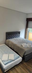 a bed with two pillows on it in a bedroom at Furadouro pine beach apartment in Ovar +41 photos