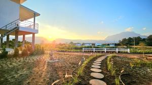a building with a fence and a fountain in a yard at Doi Luang Vista Homestay in Ban Mae To