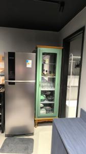 a kitchen with a refrigerator and a green cabinet at Studio de Praia in Matinhos