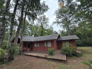 a small red house with a deck in the woods at Cabañas en Pucón CASA TUWA in Pucón +41 photos