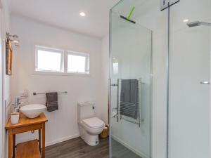 a bathroom with a toilet and a glass shower at Aroha Cottage in Ohakune +28 photos