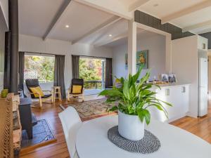 a living room with a white table and a plant at Aroha Cottage in Ohakune