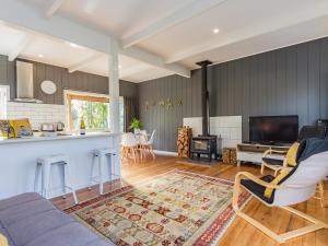 a living room with a couch and a kitchen at Aroha Cottage in Ohakune