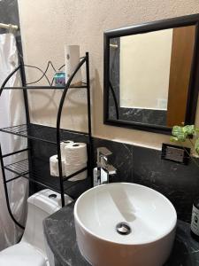 a bathroom with a sink and a mirror and a toilet at Casa compartida de 1 habitación a 10 min de la playa in La Paz +5 photos
