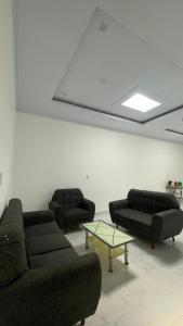 a living room with two couches and a table at Denggan KNO Guest House in Tanjungmorawa