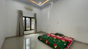 a bed in a room with a window at Denggan KNO Guest House in Tanjungmorawa +1 photo