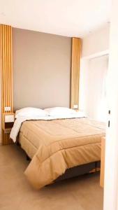 a bedroom with a large bed with yellow curtains at Villa Gesell departamento frente al mar in Villa Gesell