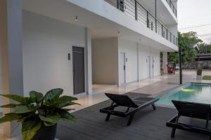 ein Haus mit Swimmingpool und zwei Stühlen in der Unterkunft Hotel Le Naga in Sakon Nakhon