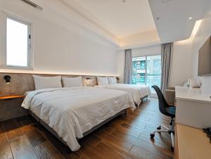 a hotel room with two beds and a desk at Hanpin Homestay in Yuli