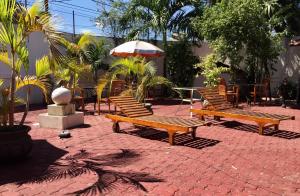 a patio with benches and a table with an umbrella at Dili Central Stay Apartment 60mts2 in Dili +6 photos