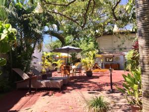 a patio with tables and chairs and an umbrella at Dili Central Stay Apartment 60mts2 in Dili