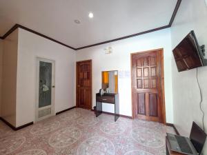 a room with a door and a table with a laptop at Golden palm rise resort in Libaong