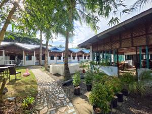 a courtyard of a house with palm trees at Golden palm rise resort in Libaong