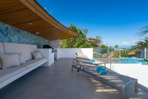 a patio with two wooden benches and a kitchen on at Penthouse Residence 8 Suite 2 in Nathon Bay +21 photos