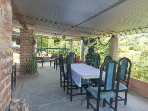ein Tisch und Stühle auf einer Terrasse mit einem Tisch in der Unterkunft Harmony Risk in Sasaima