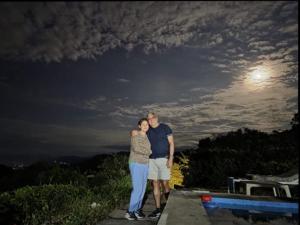 Ein Mann und eine Frau posieren nachts für ein Foto. in der Unterkunft Harmony Risk in Sasaima