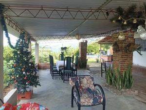 eine Veranda mit Weihnachtsbaum, Tisch und Stühlen in der Unterkunft Harmony Risk in Sasaima