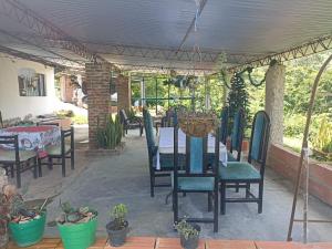 eine Terrasse mit Tisch, Stühlen und Pflanzen in der Unterkunft Harmony Risk in Sasaima