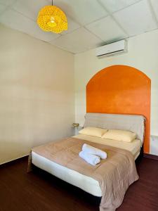 a bedroom with a large bed with a wooden headboard at Liv Bumi Oasis in Pantai Cenang