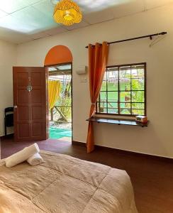 a bedroom with a bed and a large window at Liv Bumi Oasis in Pantai Cenang