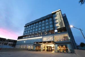 a large building with a lit up facade at dusk at Muraya Hotel Aceh in Banda Aceh