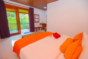 a bedroom with a large bed with an orange blanket at Forest Edge Villa in Ella