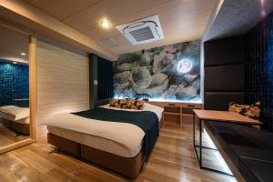 a bedroom with a bed and a wall with a painting at HOTEL FIVE -Adult Only- in Osaka