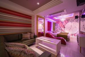 a room with a couch and a room with a bed at HOTEL FIVE -Adult Only- in Osaka