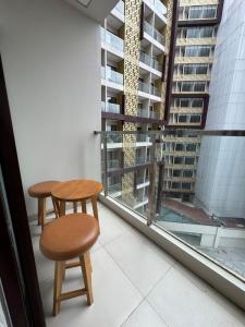 two tables and a stool in front of a window at Apartment Amarta Studio with Living Room in Yogyakarta