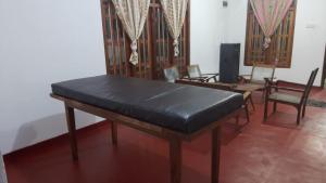 a room with a table and chairs and a couch at Sinharaja Backpacker Homestay in Kandilpana