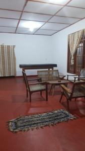 a room with a table and chairs and a piano at Sinharaja Backpacker Homestay in Kandilpana