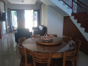 a living room with a table and chairs and a staircase at Villa Atlas in Batu