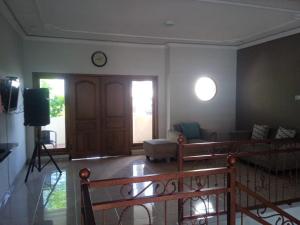 a living room with a couch and a clock on the wall at Villa Atlas in Batu