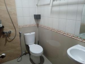 a bathroom with a toilet and a sink at Villa Atlas in Batu
