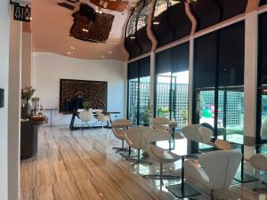 ein Zimmer mit Stühlen, Tischen und einem Kamin in der Unterkunft Hotel Le Naga in Sakon Nakhon