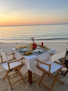 a table on the beach with two chairs at Green Papaya Beach Resort, Koh Phangan in Salad Beach +141 photos