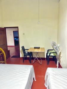 a room with two beds and a table and chairs at Diyakalana Rest in Ginigathena +43 photos