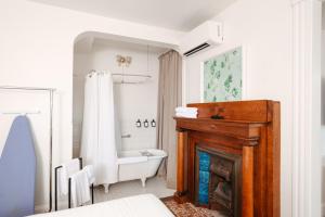 a bathroom with a tub and a toilet and a fireplace at Norment Parry by The Wellborn in Orlando +81 photos