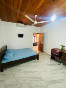 a bedroom with a blue bed and a desk at Open Sky Villa in Hikkaduwa