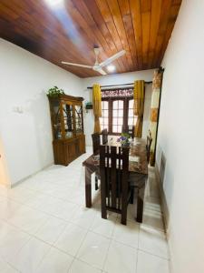 a dining room with a wooden ceiling and a table and chairs at Open Sky Villa in Hikkaduwa +21 photos