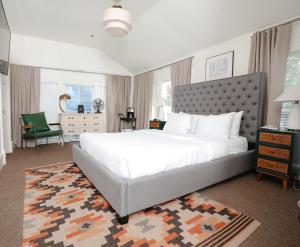a bedroom with a large white bed and a green chair at Norment Parry by The Wellborn in Orlando