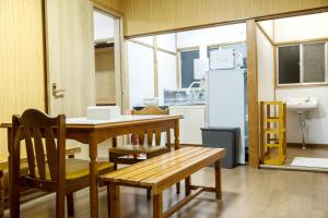 a kitchen with a table and chairs and a refrigerator at 伊豆の宿 静川 in Ito