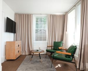 a living room with two green chairs and a table at Norment Parry by The Wellborn in Orlando