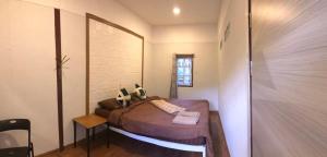 a small bedroom with a bed and a window at Palacoffeehouse ปางอุ๋ง in Ban Huai Makhuea Som