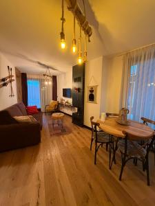a living room with a table and a couch at Winter Park Residence Bjelasnica in Bjelašnica