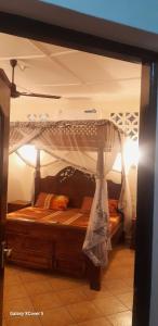 a bed with a canopy in a room at Villa LeoMar Diani Beach in Diani Beach +116 photos