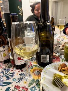 a glass of white wine next to a bottle of wine at Lifessenza Homestay in Khajjiar  +23 photos