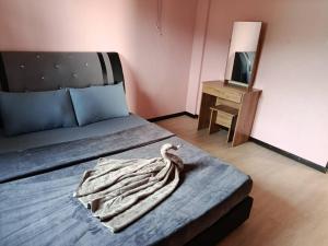 a bedroom with a bed with a towel on it at Dongorit Cabin 2 The three rooms in Kampong Kundassan